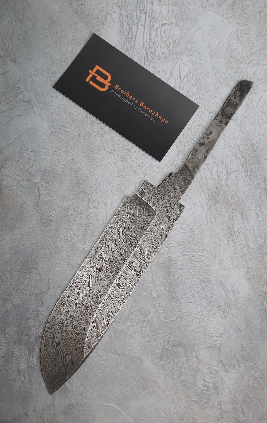 Hand-forged Damascus steel blade made from U8A, ShKh-15, 5KhNMA, and 45 steel – 85 mm length, etched finish Hand-forged Damascus steel blade made from U8A, ShKh-15, 5KhNMA, and 45 steel – 85 mm length, etched finish